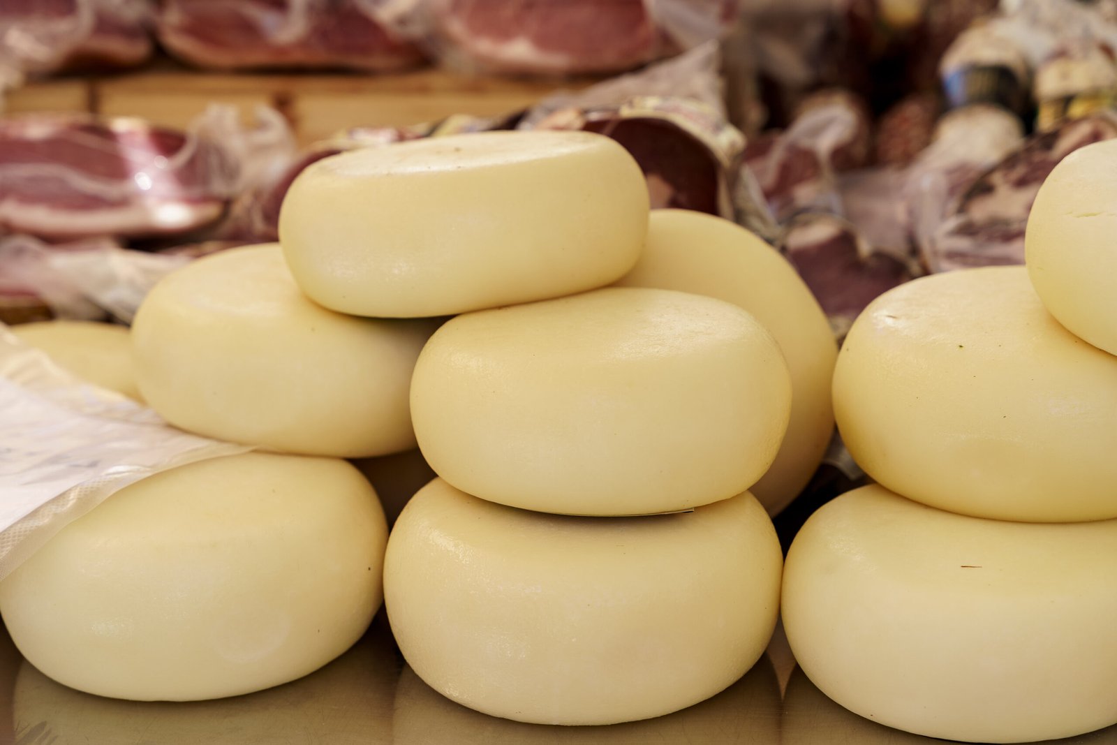 Small round pecorino cheeses stacked on a counter