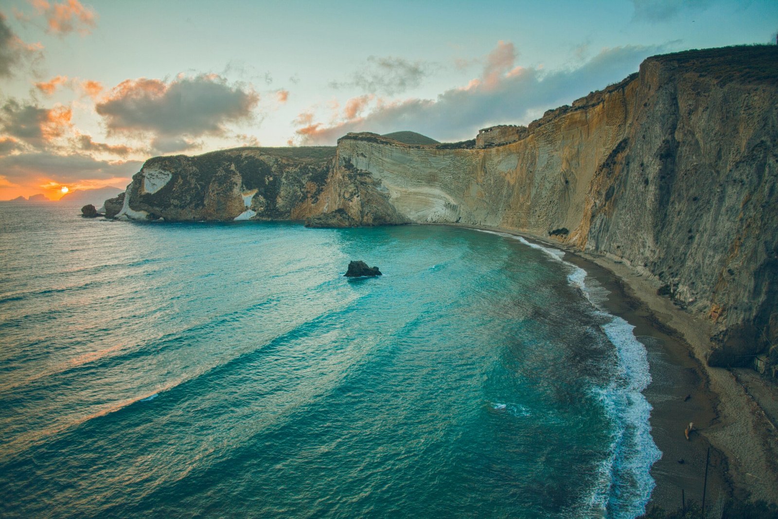 Rugged cliffs and turquoise sea along the Italian coast at sunset