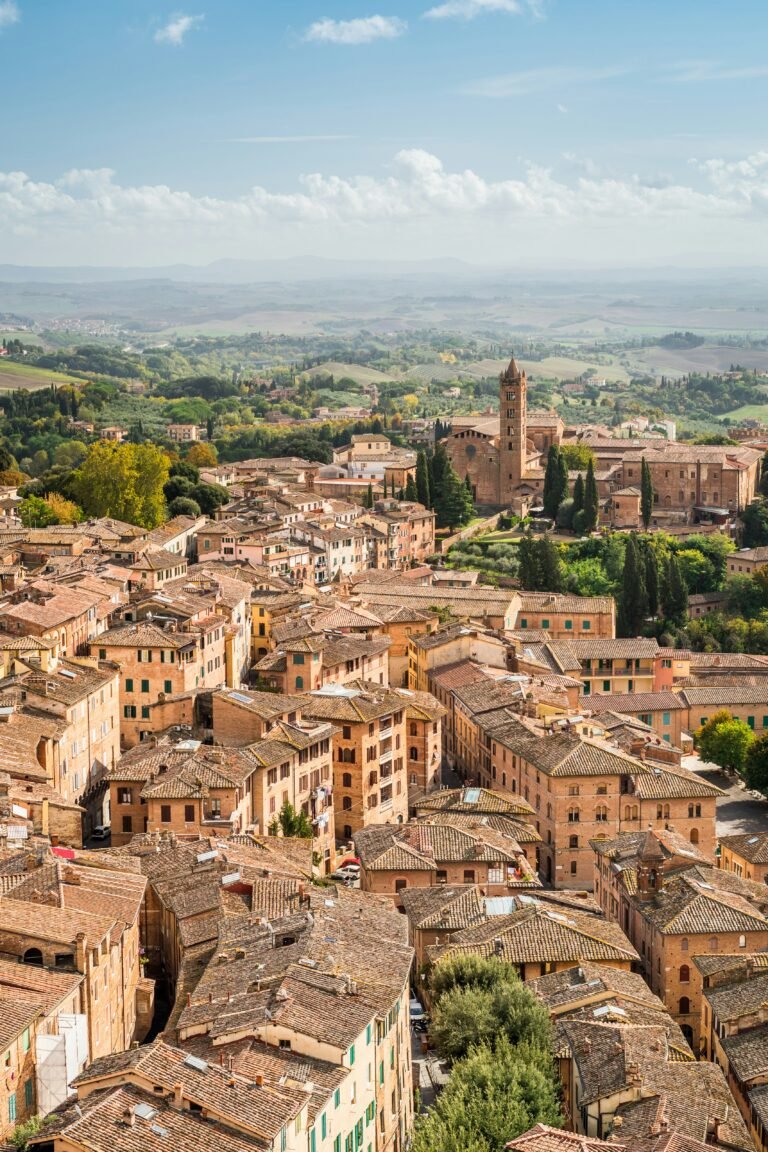 View over the terracotta rooftops and towers of Siena towards the Tuscan hills View over the terracotta rooftops and towers of Siena towards the Tuscan hills