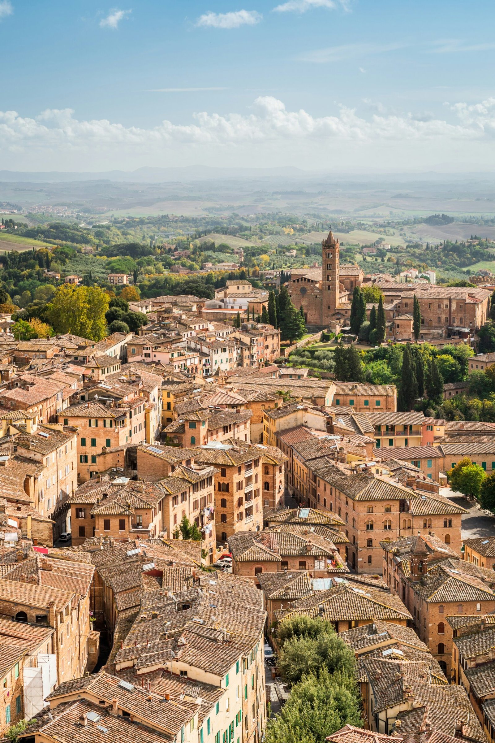 View over the terracotta rooftops and towers of Siena towards the Tuscan hills
