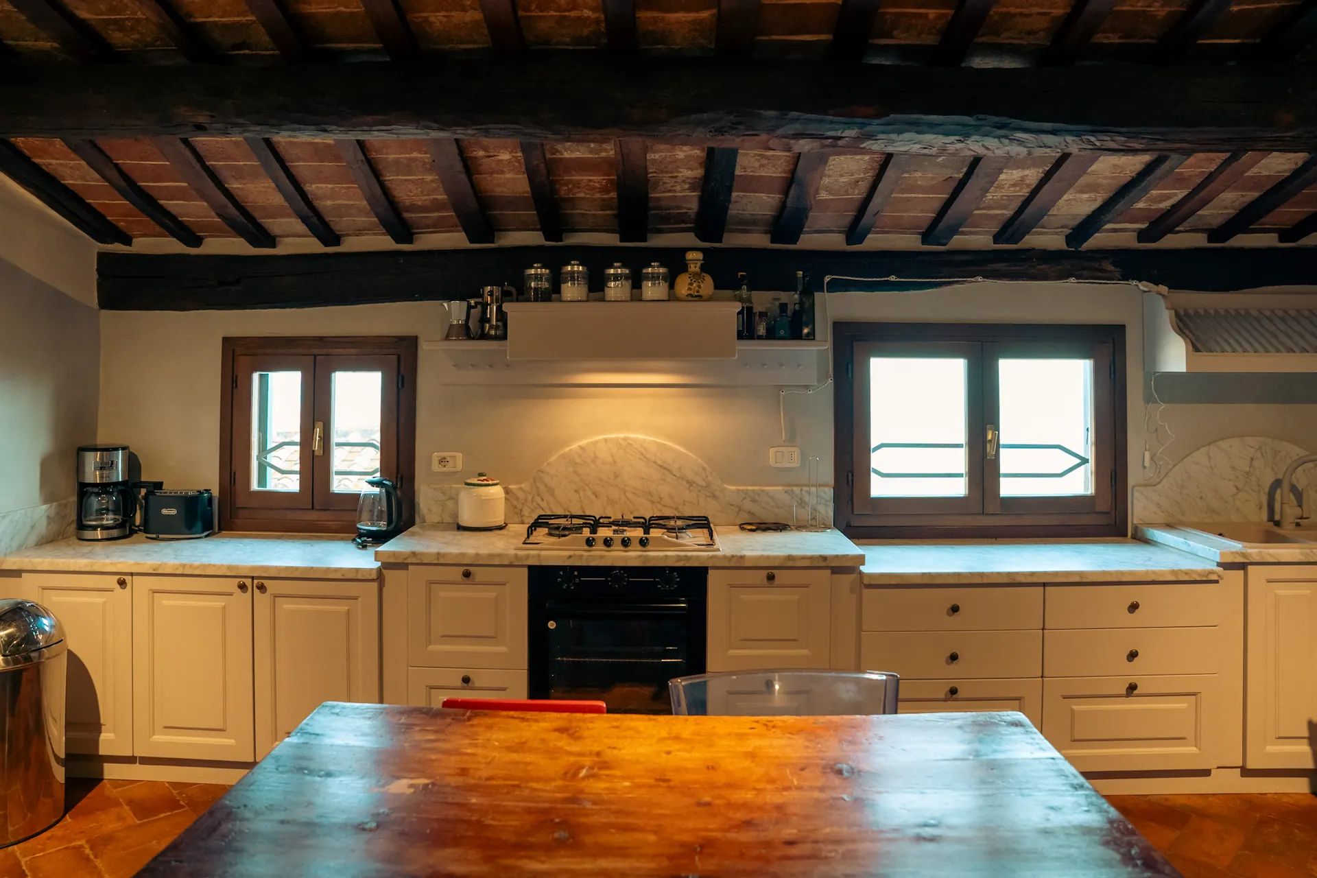 cortona-charme-apartment-kitchen-wooden-beams Fully equipped kitchen with wooden-beam ceiling and dining table at Cortona Charme apartment, Cortona
