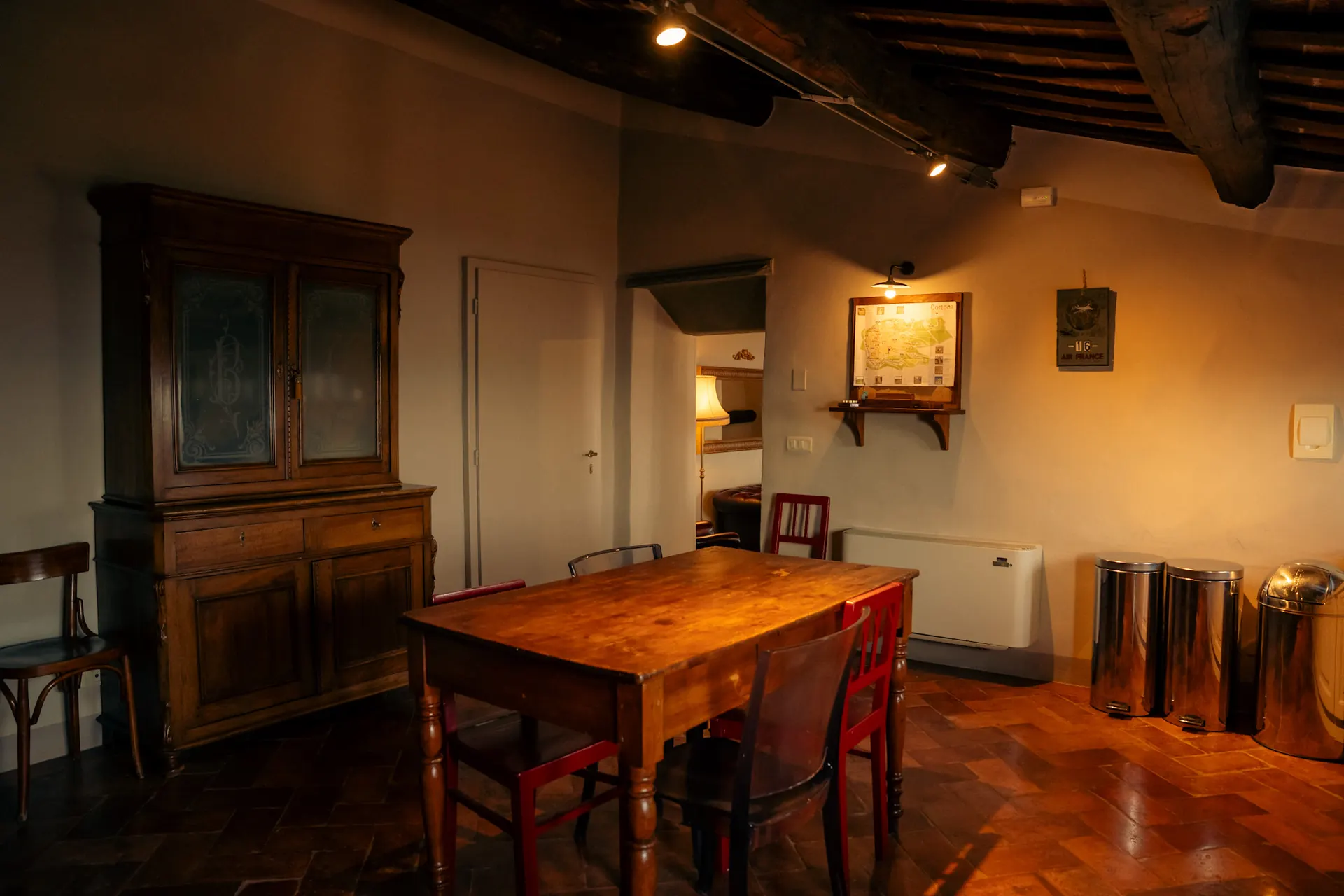 cortona-charme-apartment-living-dining-room-beamed-ceiling Living and dining room with antique cupboard, wooden table and beamed ceiling at Cortona Charme apartment, Cortona