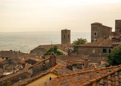View over the terracotta rooftops and medieval towers of Cortona towards the Valdichiana valley from Cortona Charme apartment