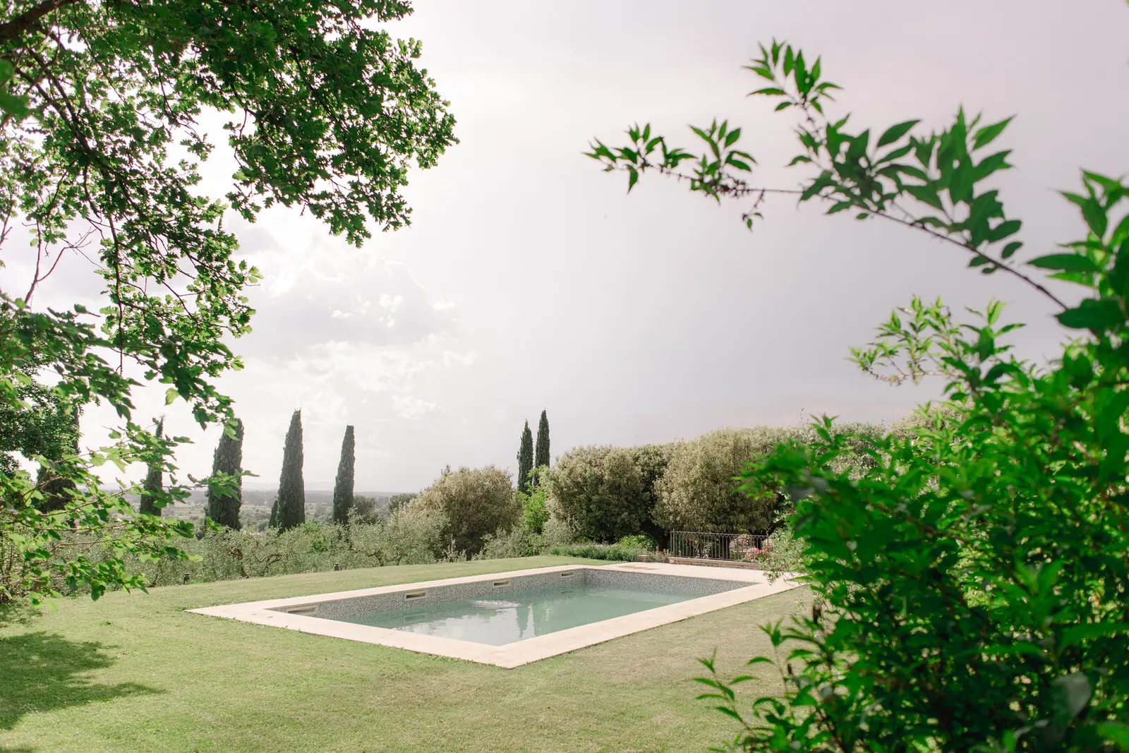 in-villa-house-cortona-swimming-pool-garden-cypress-view Private swimming pool on the lawn surrounded by trees and cypresses at In-Villa House, Cortona