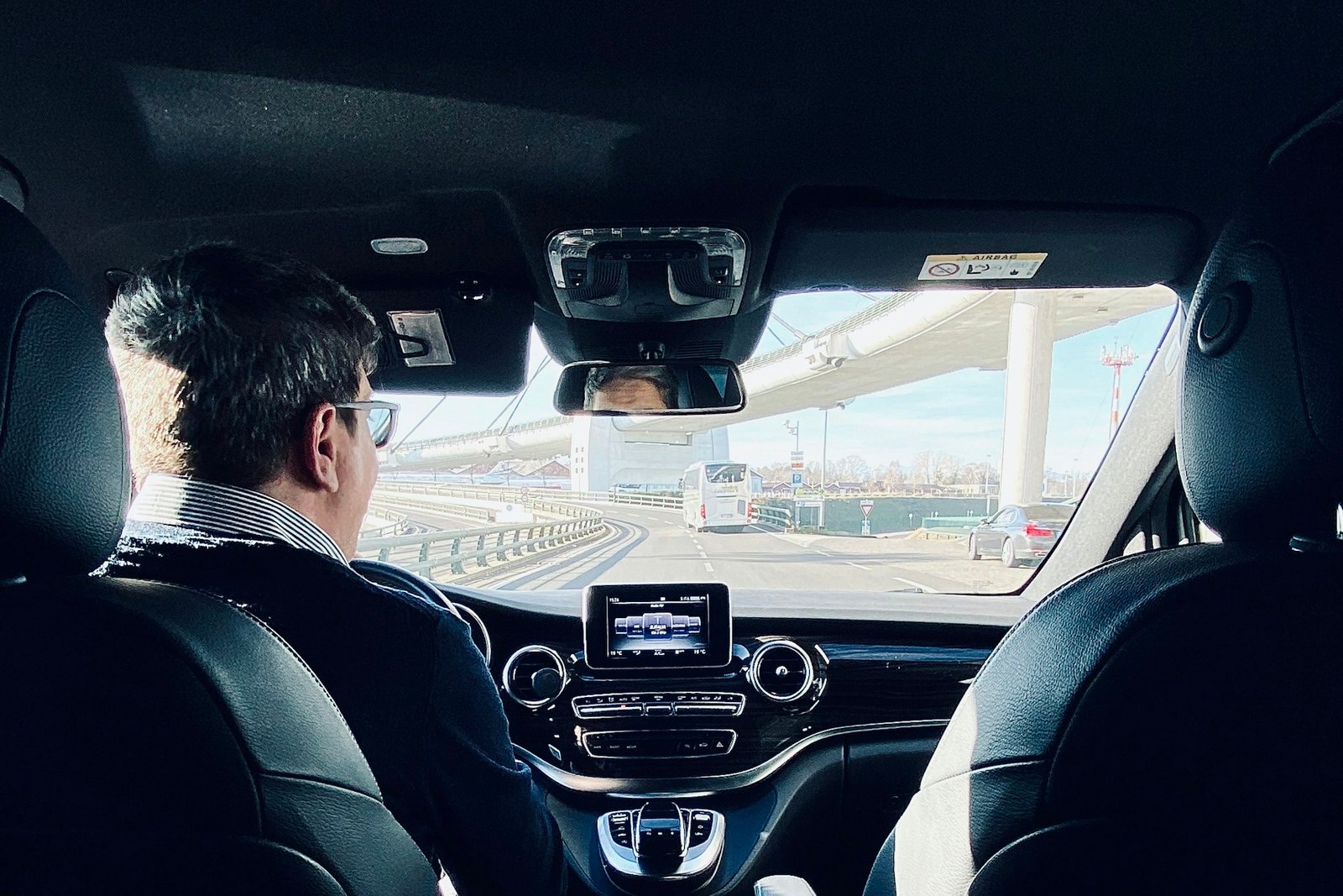 Private driver in a dark suit at the wheel of a car Private driver in a dark suit at the wheel of a car