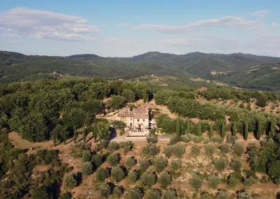 Aerial view of Villa Erbolino surrounded by olive groves, cypresses and woods in the Chianti hills
