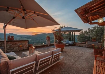 Panoramic terrace with parasols and outdoor sofas at sunset over the Chianti hills, Villa Erbolino