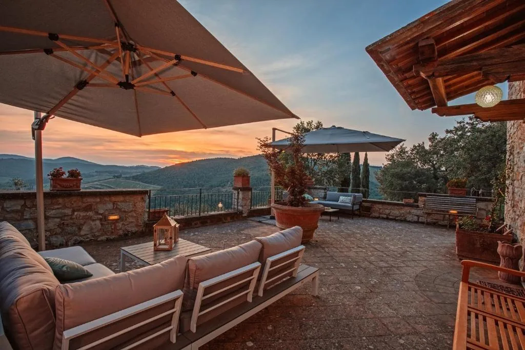 villa-erbolino-chianti-panoramic-terrace-sunset Panoramic terrace with parasols and outdoor sofas at sunset over the Chianti hills, Villa Erbolino