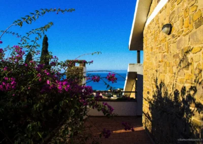 Bougainvillea framing the sea view beside the stone walls of Villa Monte Bianco