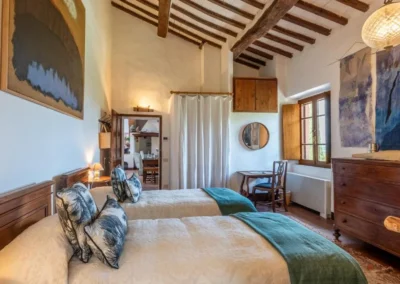 Bedroom with a double and a single bed, beamed ceiling and contemporary art at the villa