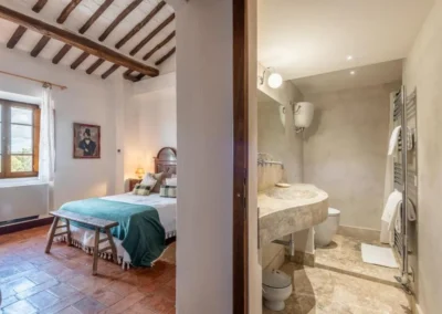 Double bedroom opening onto a bathroom with stone washbasin and shower at the villa