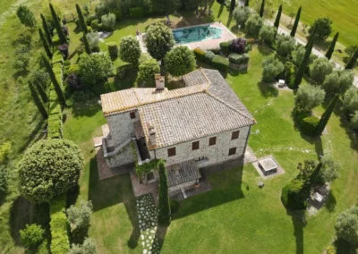 Aerial view of the stone villa with garden, cypresses and private pool
