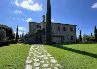 Stone path across the lawn leading to the villa and its cypress